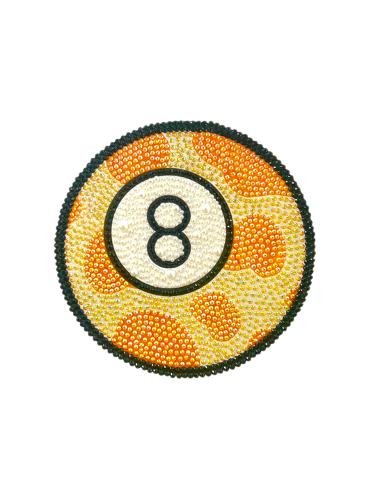 Photograph of a rhinestone-bedazzled orange, white, and black-accented 8-ball.