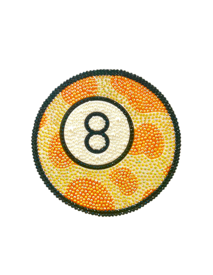 Photograph of a rhinestone-bedazzled orange, white, and black-accented 8-ball.