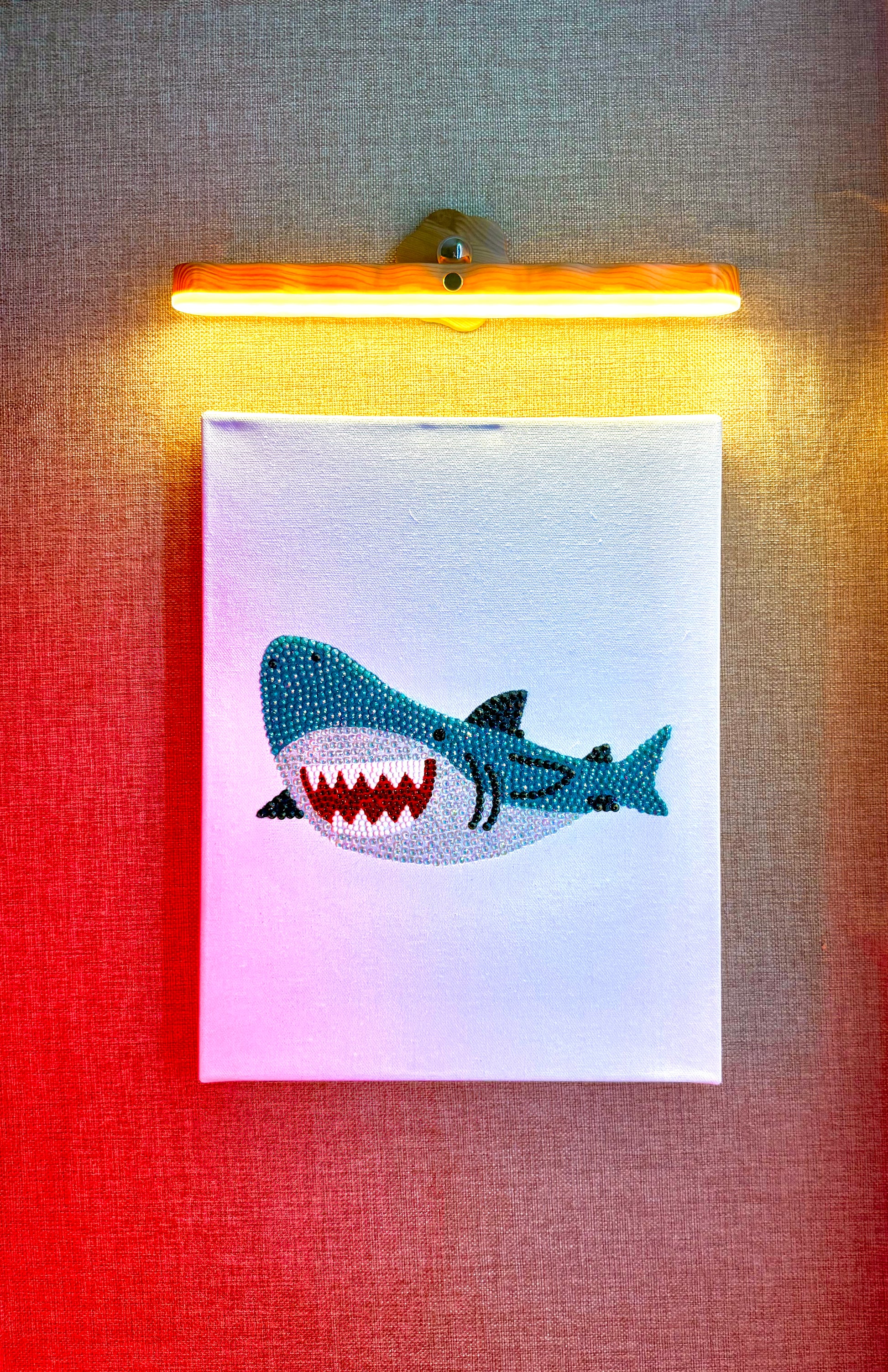 Rhinestone-bedazzled canvas wall art of a cartoon shark.