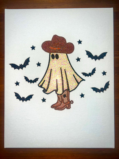 Hand-bedazzled canvas art featuring a spooky figure with a hat and boots, surrounded by bats against a white background.